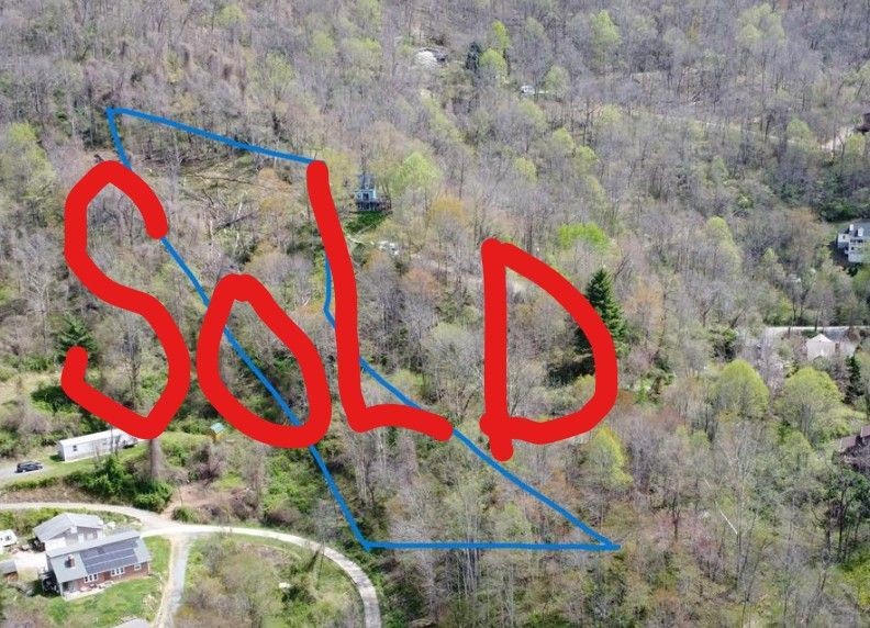 Aerial view of wooded land with 'Sold' written in bold red letters across the image.